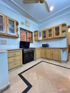 cocina grande con armarios de madera y techo en Modern 3-Bed Retreat E11 PEACEFUL, en Islamabad
