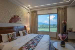 a bedroom with a bed and a large window at Hotel Yog Ganga Retreat in Rishīkesh