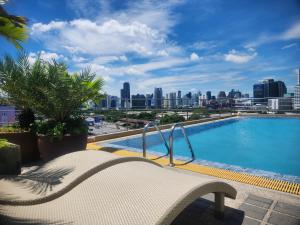 een zwembad met uitzicht op de skyline van de stad bij Interchange Tower Serviced Apartment - SHA Extra Plus in Bangkok