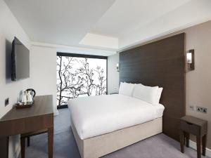 a bedroom with a large white bed and a window at Central Park Hotel in London