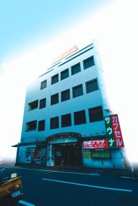 un edificio azul con señales en el costado en Capsule Hotel & Sauna Ikebukuro Plaza, en Tokio