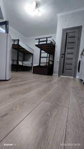 een lege kamer met 2 stapelbedden en een houten vloer bij Квартира ЦТ Алматы Иссыкуль in Cholpon-Ata