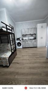 a room with a bed and a kitchen in it at Квартира ЦТ Алматы Иссыкуль in Cholpon-Ata