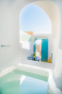 Habitación blanca con piscina y mesa en Calliope's Villa with jacuzzi, en Pirgos