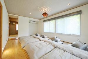 una fila de camas en una habitación con ventana en SHELTER道志 ふらっと高尾山 都心から70分 最大10名 貸切サウナ 雨でもBBQok 焚火花火, en Sagamihara 66 fotos más