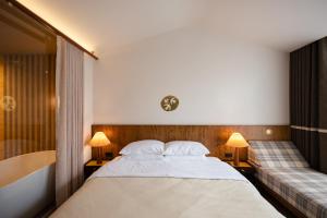 a bedroom with a large bed and a bath tub at hotel hommtown chiang mai in Chiang Mai