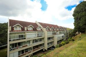 an apartment building on the side of a hill at Novo Bhaus Gaudi Campos do Jordão Loft Duplex - Linda Vista - 600m do Capivari in Campos do Jordão
