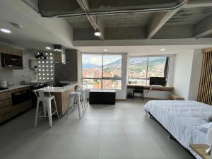a bedroom with a bed and a kitchen with a view at Edificio Aiana Verde by Host Medellin in Medellín +22 photos