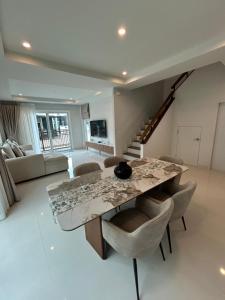 a living room with a marble table and chairs at Supalai Rent BANG TAO PHUKET in Phuket