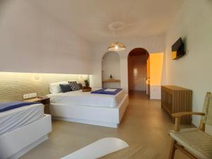 a hotel room with two beds and a tv at Amodari studios on the beach in Plaka