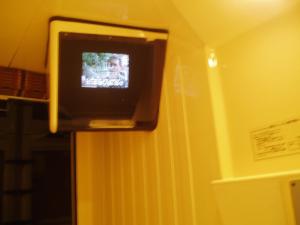 a television on a wall in a room at Capsule Hotel & Sauna Ikebukuro Plaza in Tokyo