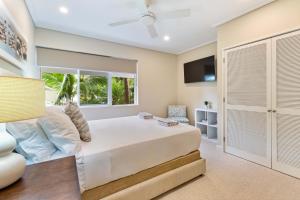 a bedroom with a large white bed and a window at Mirage Resort Villa 428 with access to Sheraton Facilities in Port Douglas