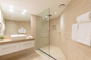 a bathroom with a glass shower and a sink at Mirage Resort Villa 428 with access to Sheraton Facilities in Port Douglas +3 photos
