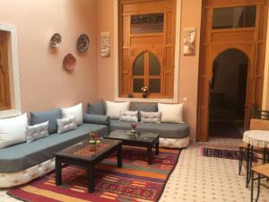 - un salon avec un canapé et une table dans l'établissement Riad Jenan Adam, à Marrakech