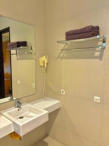 a bathroom with a sink and a mirror and a phone at COZY Boutique Guest House in Malang +29 photos