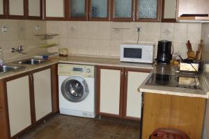 a kitchen with a washing machine and a microwave at Vacation Home Yoanna in Tryavna