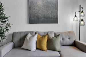 フェニックスにあるCentric 2BR In HEART of DTPHX Free Garage Parkingのリビングルーム(グレーのソファ、枕4つ付)