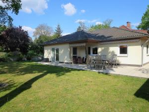 a house with a table and chairs in a yard at Ferienhaus Schillo in Rangsdorf