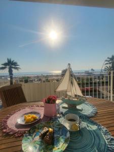 une table avec une assiette de nourriture et un voilier dessus dans l'établissement Sea Home Sunrise, à Tortoreto Lido