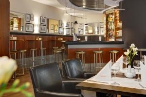 ein Restaurant mit Tischen, Stühlen und einer Bar in der Unterkunft IntercityHotel Berlin Ostbahnhof in Berlin