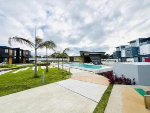 a resort with a swimming pool and palm trees at Our Gentle Nest at Batulao in Calo