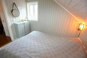 En eller flere senge i et værelse på Sommerhus Med To Terrasser Nær Risør