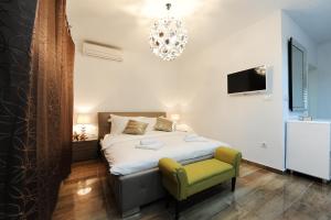 een slaapkamer met een bed, een stoel en een kroonluchter bij Primera Luxury Studio in Zadar