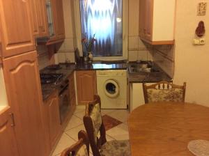 uma cozinha com uma mesa e uma máquina de lavar roupa em Szundi Szobák em Pécs