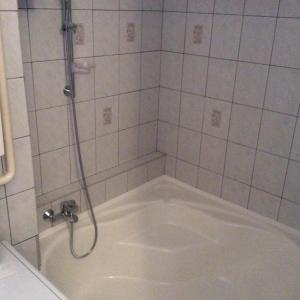 uma cabina de duche com uma banheira na casa de banho em Szundi Szobák em Pécs