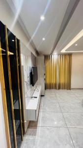 a living room with a television and a counter at 7th Heaven Hotel in Hisār