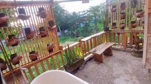a wooden balcony with a bench and potted plants at Wisnu Lumbung Uluwatu in Uluwatu