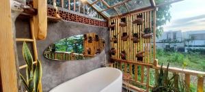 a bathroom with a mirror and a tub and a toilet at Wisnu Lumbung Uluwatu in Uluwatu