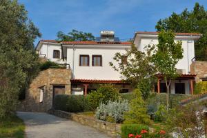 a large white house with a stone wall at Diplomats' Holidays in Chorto