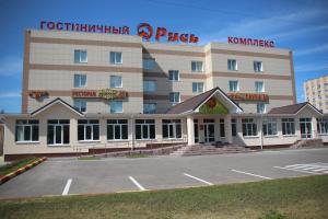 a hotel with a parking lot in front of it at Hotel Rus in Tolyatti
