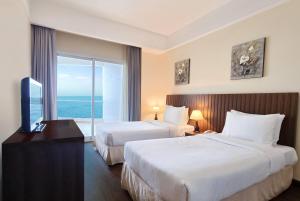 A bed or beds in a room at Ramada by Wyndham Beach Hotel Ajman