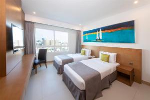 A bed or beds in a room at Ramada by Wyndham Beach Hotel Ajman