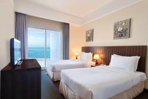 A bed or beds in a room at Ramada by Wyndham Beach Hotel Ajman