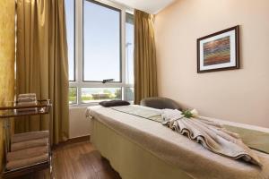 A bed or beds in a room at Ramada by Wyndham Beach Hotel Ajman