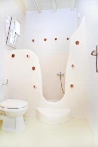 a white bathroom with a toilet and a shower at Altana Boutique Hotel in Tinos