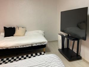 a bedroom with a bed and a flat screen tv at Station House Daechi in Seoul