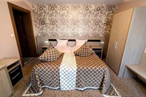 - une chambre avec un lit doté d'une couette et d'oreillers dans l'établissement Vile Verdi, à Băile Felix
