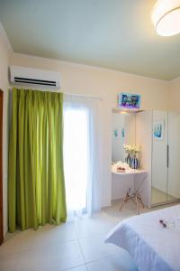 ein Schlafzimmer mit einem grünen Vorhang und einem Schreibtisch in der Unterkunft Mansion House Parga in Parga