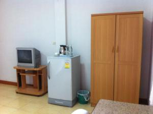 Zimmer mit einem kleinen Kühlschrank und einem TV in der Unterkunft Pikul Apartment Hotel in Nong Khai