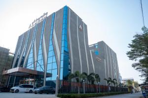 a building with cars parked in front of it at Puli Passo Hotel Casino in Krong Poi Pet