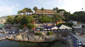 een resort met een gebouw op een heuvel naast het water bij Hotel Continental in Santa Margherita Ligure