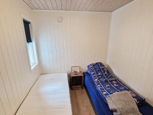 a small room with a bed and a table at 4 star holiday home in Huglo in Nordhuglo