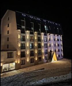 a building with lights on the side of it at night at Kopaonik-President kop apartment 101 free wellness&spa in Kopaonik