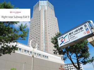 ein Schild vor einem hohen Gebäude in der Unterkunft Hotel Emisia Sapporo in Sapporo