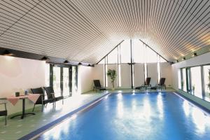 a swimming pool with chairs and a table in a building at Hotel Hirschen in Glottertal