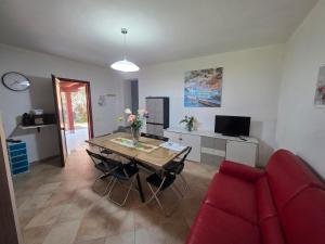 a living room with a table and a red couch at Villa Giulia Grande in Castiadas